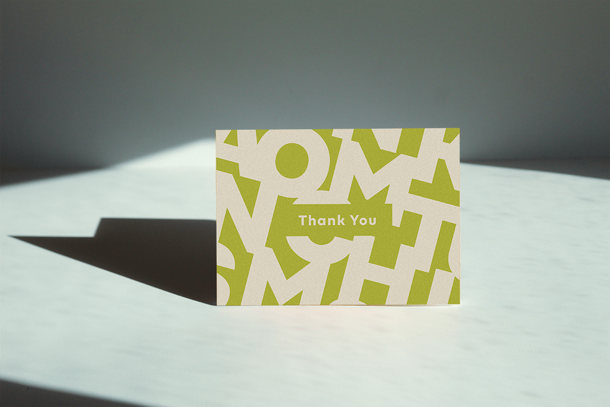 green and white colored Thank you greeting card thank reads "thank you" and has the letter's of "Thank you" in the background'
