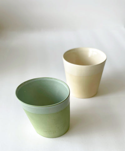 2 sleek and simple local cup. One colored sage and the other sand. Cups have a slanted profile and smooth finish 