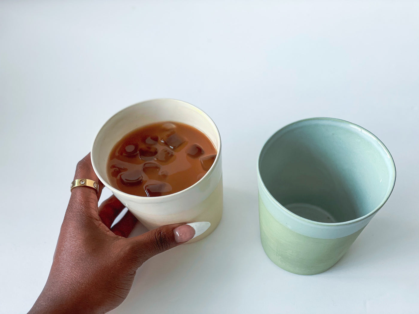 2 sleek and simple local cups. One colored sage and the other sand. Cups have a slanted profile and smooth finish 
