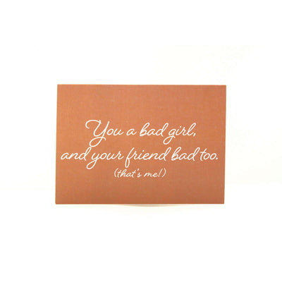 Orange card with a white cursive text that reads 'You a bad girl, and your friend bad too. (that's me!)"