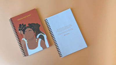 Daughter diary cover with an illustration of three black women back to back looking up as well as inside of diary showing empty pages.