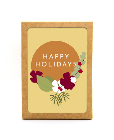 pastel yellow holiday floral greeting card that reads "happy holidays" and illustrates green, red and white flowers. Card is shown in box that full set comes in.